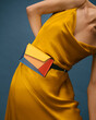 © Ulas&Merve/Stocksy - Fashionable Woman in Yellow Dress with Colorful Belt Bag