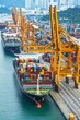 © Nipa - Busy Seaport Activity Image of a bustling seaport with multiple ships docked, containers being moved by cranes, and port activity