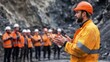 © indyntk - Resourceful miner conducting a safety briefing for a diverse team in a rugged mining site