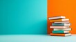 © Emqan - A stack of colourful books on an orange and blue background.