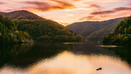 Poster - lake in mountains on a sunny evening. forest reflecting in the water. beautiful scenery of romania in autumn season. natural environment