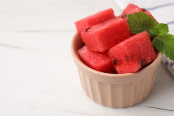 Wall Mural - Pieces of tasty watermelon and mint in bowl on white table, closeup. Space for text