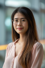 Wall Mural - A woman with long brown hair and glasses is smiling for the camera