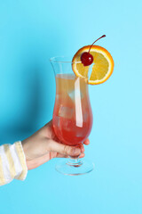 Wall Mural - Woman with glass of refreshing cocktail on light blue background, closeup