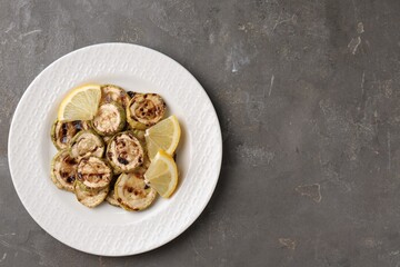 Poster - Tasty grilled courgette slices with lemon on grey textured table, top view. Space for text