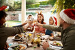 © Chanelle2000/peopleimages.com - Family, drinks and toast for Christmas, celebration and lunch outdoor with food, party and glass in backyard. Mom, dad and children for holiday, bonding and brunch with support, home and fun