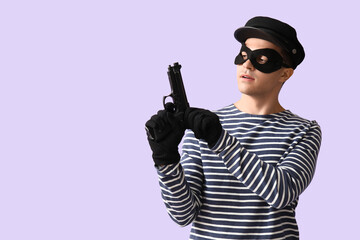 Wall Mural - Male thief with gun on lilac background