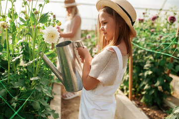 Wall Mural - Working together. Mother and daughter are in the greenhouse