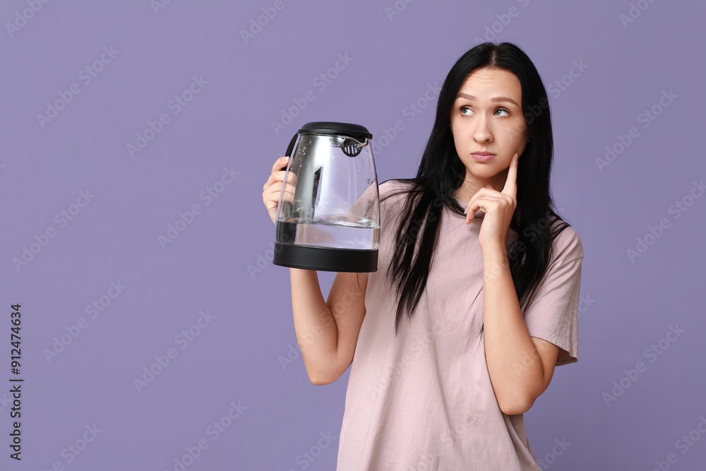 Thoughtful young woman with modern electric kettle on lilac background