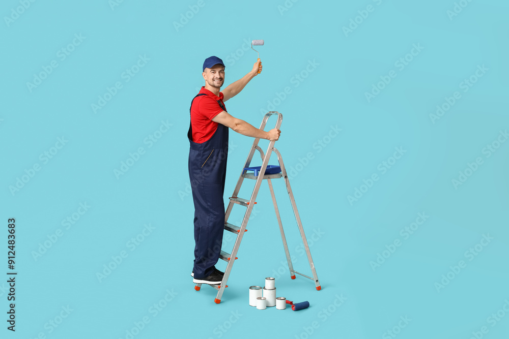 Portrait of male painter with paint roller and stepladder on blue background