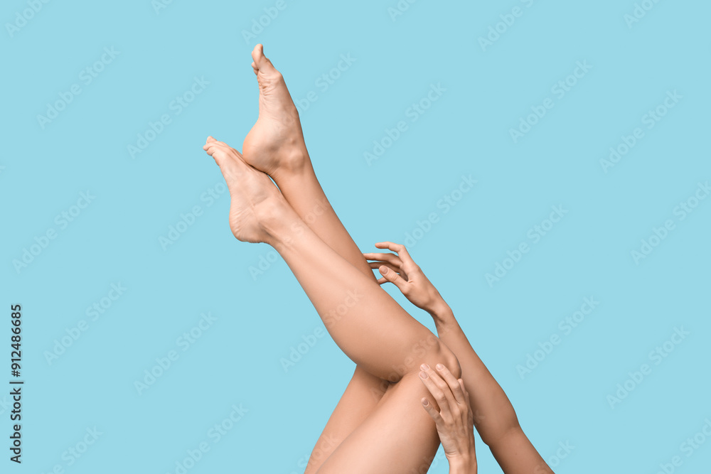 Legs of young woman on blue background. Epilation concept
