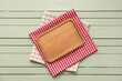 © Pixel-Shot - Table setting with board and napkins on green wooden background