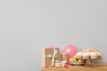 Wall Mural - Table with different sweets, gifts and balloons for birthday party against white wall