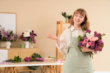 Wall Mural - Female florist holding beautiful bouquet with lilacs in flower shop