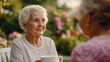 © Rutchaneewan - A heartwarming scene of an elderly woman and her caregiver sharing tea in a serene garden, highlighting home care and meaningful leisure activities.