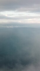 Wall Mural - aerial vertical view over foggy and fluffy clouds. blue sky sun, sea fog. abstract nature summer oce