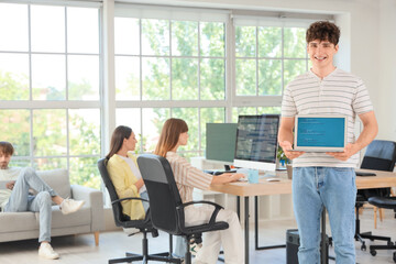 Canvas Print - Male programmer with laptop in office