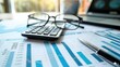 © A Denny Syahputra - Calculating financial data with graphs and tools on a desk in the morning sunlight