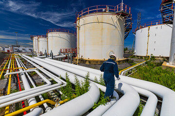 Wall Mural - Male worker inspection at steel long pipes and pipe elbow in station oil factory during refinery valve of visual check