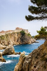 Wall Mural - Dubrovnik's old town fortified walls and coastline with blue waters and rocky cliffs in Croatia