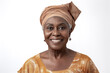 © larrui - Older woman in beige traditional attire and headwrap smiling. Studio portrait. Cultural heritage and fashion concept
