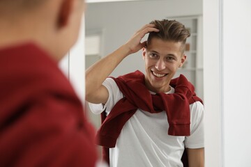 Canvas Print - Handsome man looking at mirror at home