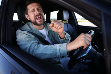 Wall Mural - Man singing in car, view from outside