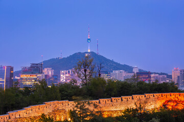 Wall Mural - Seoul city at night and Traditional Korean city walls and skyscrapers in Dongdaemun, with Namsan Mountain and Namsan Tower in the background, Seoul, South Korea.