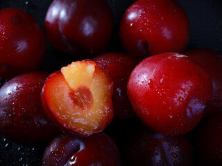 fresh plucked plum is cut into two halves	