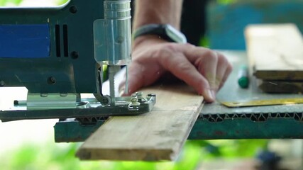 Wall Mural - A worker cuts a board with a jigsaw