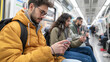 © niwat - Male and female passengers using mobile phone in a metro