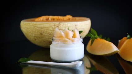 Wall Mural - sweet homemade yogurt in a jar with pieces of ripe melon