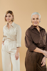 Wall Mural - A mature woman shares a proud moment with her adult daughter, both stylishly dressed.