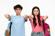 © InsideCreativeHouse - Sad upset high school pupils students teenagers classmates boy girl friends in casual clothes with bags showing thumb down sign gesture isolated on white background. Education back to school concept