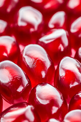 Wall Mural - Macro shot of the texture of a pomegranates seeds showcasing the glossy red arils and juicy texture 