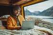 © Patcharaphon - Freelance man working on computer in camper van. Road trip, motor home, work from everywhere concept