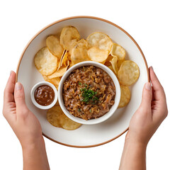 A plate of eggplant dip, chips, and a side of sauce, held in two hands. Perfect for food blogs, restaurant menus, or recipe websites. (Transparent PNG background)