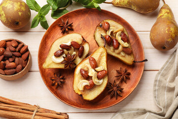Wall Mural - Delicious baked pears with nuts, anise stars and cinnamon sticks on light wooden table, flat lay