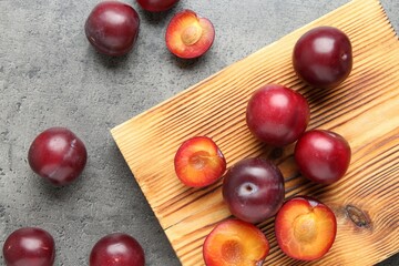 Wall Mural - Fresh plums on grey textured table, flat lay