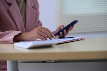 Successful Asian businesswoman sitting at desk working using laptop computer in office. Business and people concept. Businesswoman using laptop computer and working with documents.