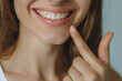 © Valeriia - Dental oral care. Stomatology dentistry concept. Beautiful female smile after white teeth pointing finger on healthy whitening procedure