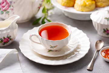 Wall Mural - Cup of tea with scones with jam and milk. Grey background. Close up.