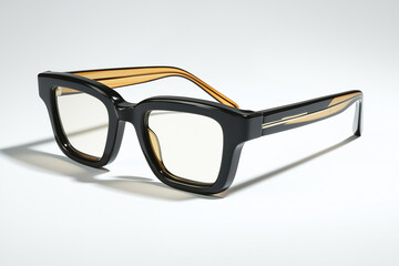 Pair of black and gold eyeglasses casting a shadow on white