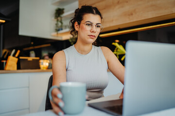 Young caucasian woman working from home on laptop