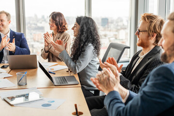 Aufkleber - A group of business professionals sit around a table in a modern office, clapping their hands in appreciation. They are dressed in business attire and are engaged in a lively discussion.