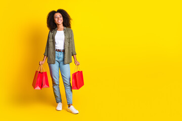 Poster - Full size photo of dreamy girl wear khaki shirt hold shopping bags look at discount empty space isolated on yellow color background