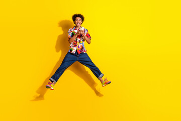 Poster - Full size photo of nice young man jump use phone wear shirt isolated on bright yellow color background