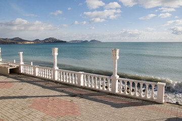 View of the embankment in Koktebel. The sea and the mountains in the distance.