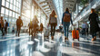 © khonkangrua - Travelers walking through a busy airport terminal, carrying luggage, bathed in natural sunlight from large windows.