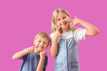 Cute happy little children with healthy teeth on purple background